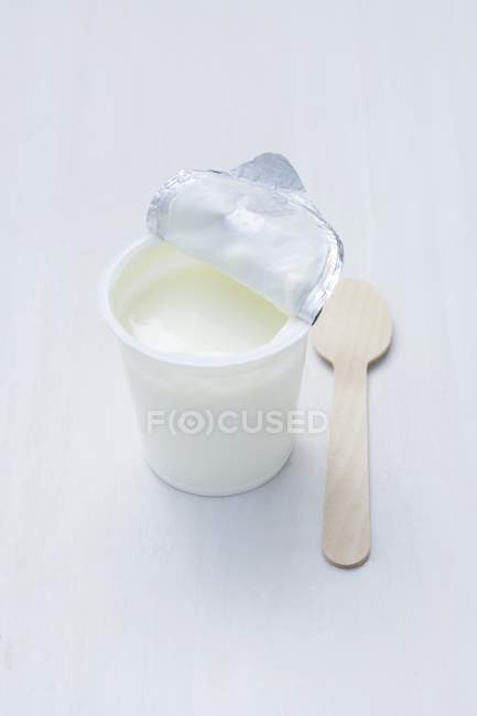 Yoghurt in opened pot — Stock Photo