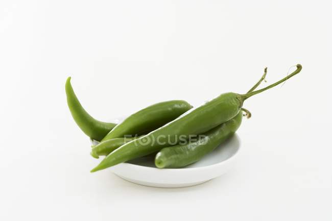 Chiles verdes frescos en el plato - foto de stock