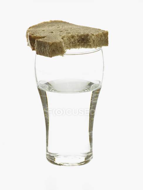 Vaso de agua y pan - foto de stock