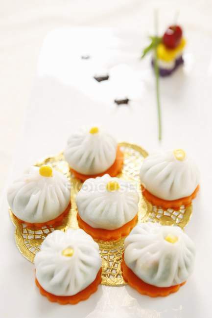 Crystal buns on golden doily and white surface — Stock Photo