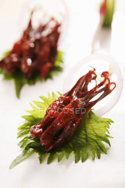 Closeup view of fried meat pieces on green leaves — Stock Photo