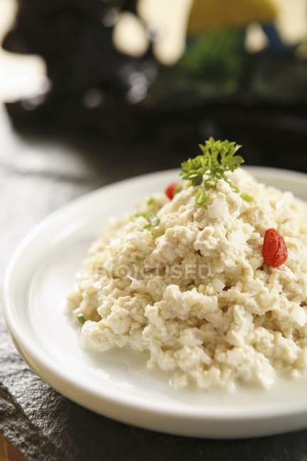 Тофу с помидорами и травой на тарелке — стоковое фото