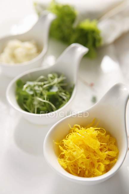 Varie insalate in piccole pentole su superficie bianca — Foto stock
