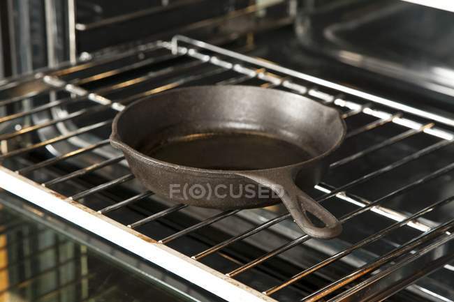Closeup view of a cast iron skillet on an oven rack — Stock Photo