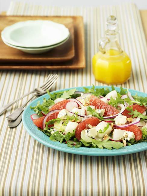 Salade de fenouil au pamplemousse et fusée sur assiette verte au-dessus de la table — Photo de stock