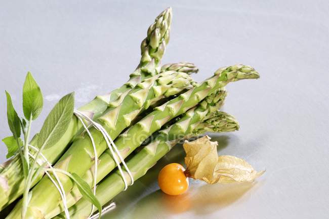 Green asparagus and physalis — Stock Photo