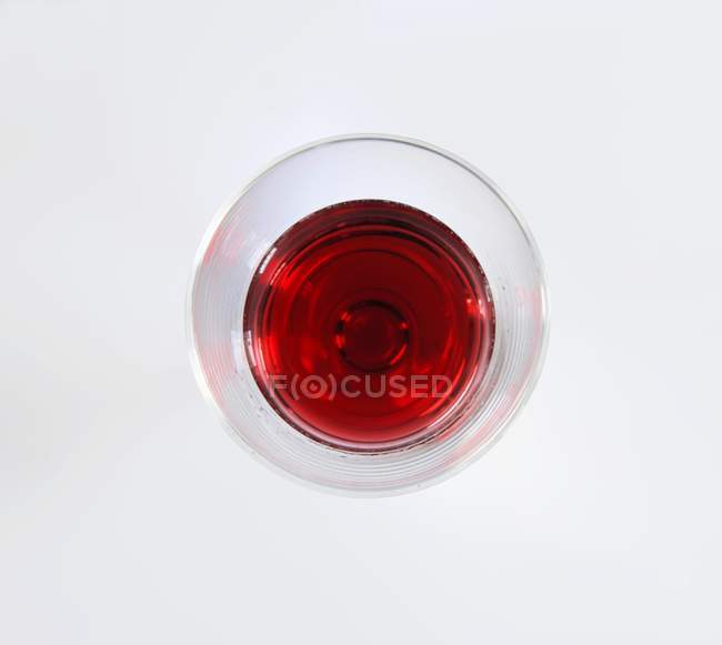 Glass of red wine on white surface — Stock Photo
