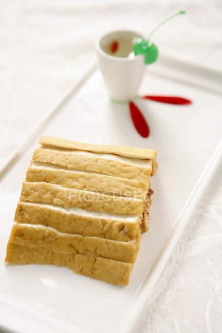 Closeup view of marinated Tofu cheese with drink and green cherry on white dish — Stock Photo