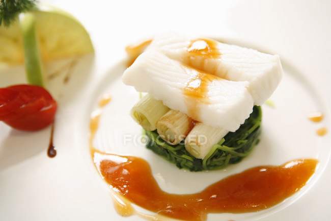 Bacalhau com legumes em prato branco — Fotografia de Stock