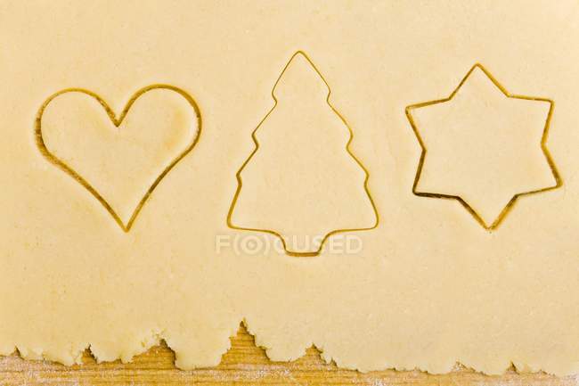 Closeup top view of biscuit dough with cut-out biscuits — Stock Photo