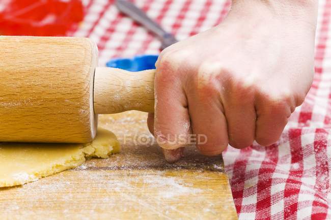 Closeup view of person rolling out biscuit dough — Stock Photo