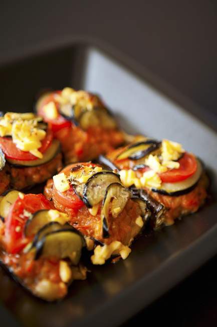 Baked Eggplant with Tomato on black plate — Stock Photo