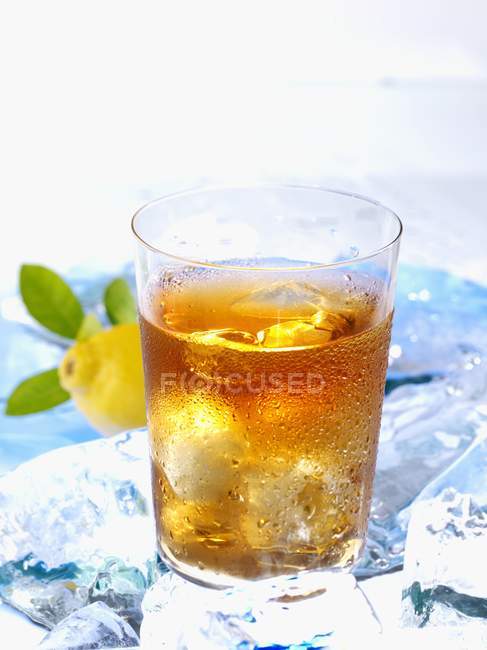 Glass of iced tea on ice cubes — Stock Photo