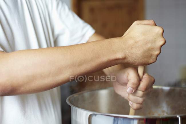 Шеф-кухар помішуючи сковороду з дерев'яною ложкою — стокове фото