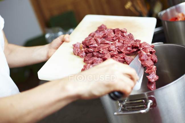 Chef tipping chopped beef — Stock Photo