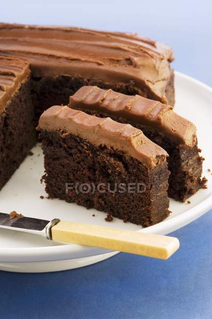 Gâteau au chocolat partiellement tranché — Photo de stock
