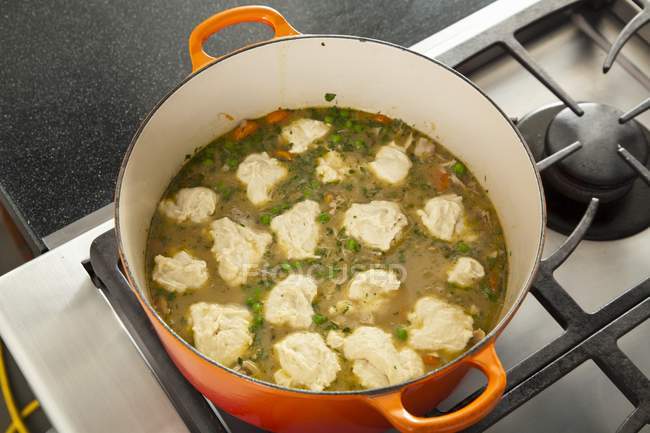 Elevated view of dumplings cooking in a pot of chicken stew — Stock Photo