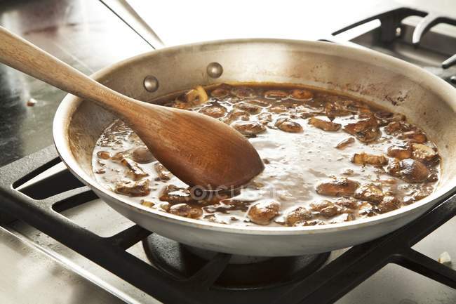 Closeup view of mushroom and wine sauce in a skillet — Stock Photo
