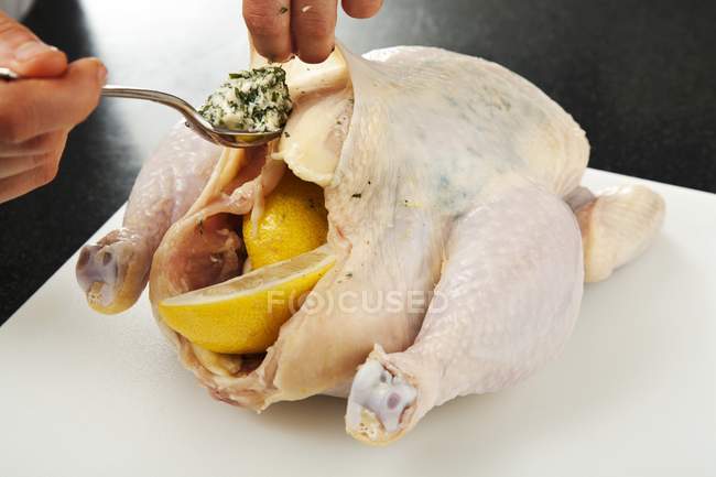 Manos humanas Añadir mantequilla en el pollo - foto de stock