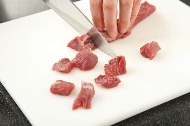 Chef cortando cordeiro em cubos — Fotografia de Stock
