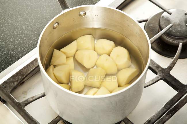 Geschälte und gehackte Kartoffeln in einem Topf mit Wasser zum Kochen — Stockfoto