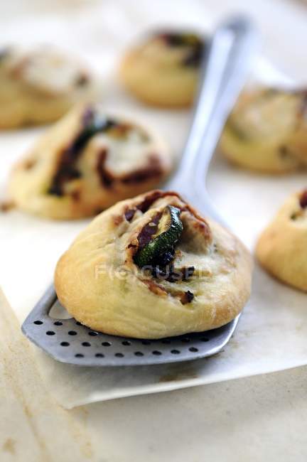 Spicy mini pastries filled with salami and courgette on server — Stock Photo