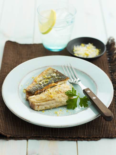 Fried Sea bass with lemon zest — Stock Photo