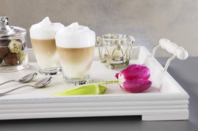Kaffee mit Milch und Pralinen — Stockfoto