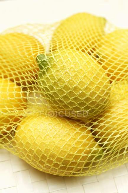 Ripe lemons in net — Stock Photo