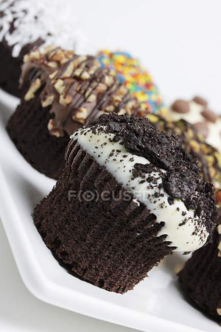 Chocolate Cupcakes com coberturas sortidas — Fotografia de Stock