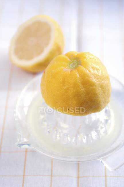 Лимонная половина на соковыжималке — стоковое фото