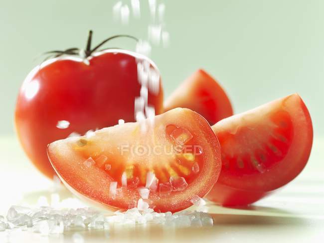 Sprinkling tomatoes with salt — Stock Photo