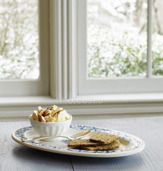 Helado de vainilla con llovizna de caramelo - foto de stock