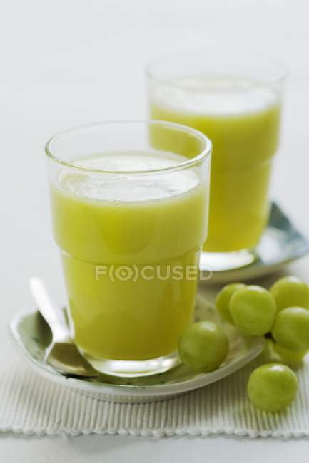 Porciones de fruta kiwi y zumo de uva - foto de stock