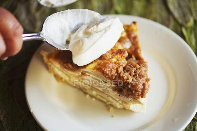 Spooning Whipped Cream onto Slice of Pie — Stock Photo