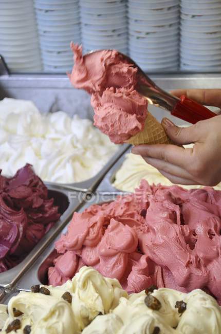 Vendedor de sorvete escavar sorvete de framboesa — Fotografia de Stock