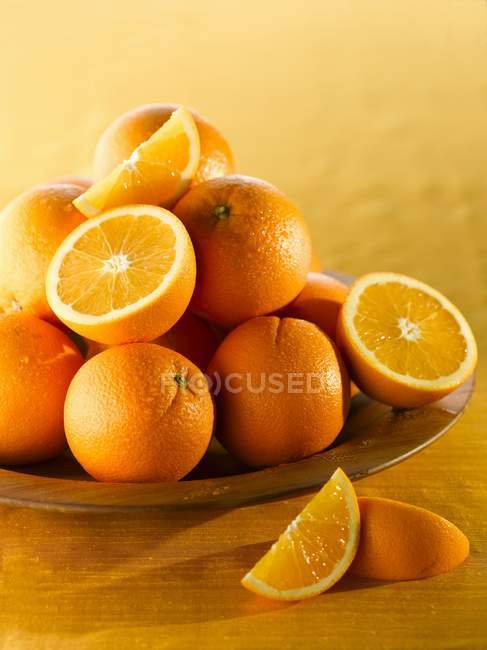 Ripe Oranges in wooden bowl — Stock Photo