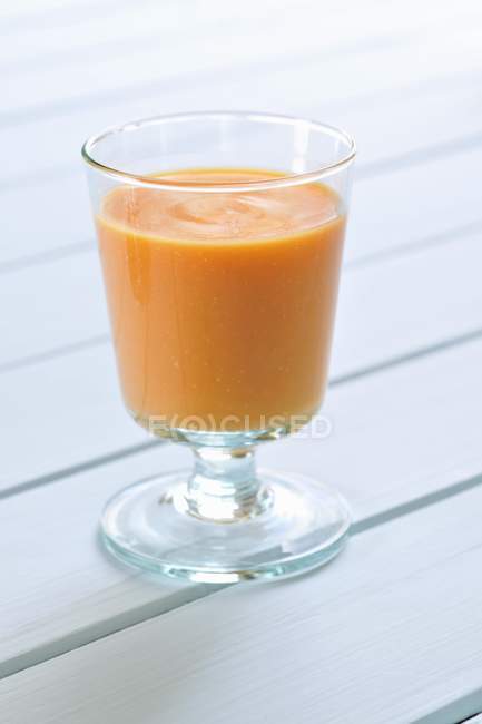 Glass of cream of carrot soup — Stock Photo