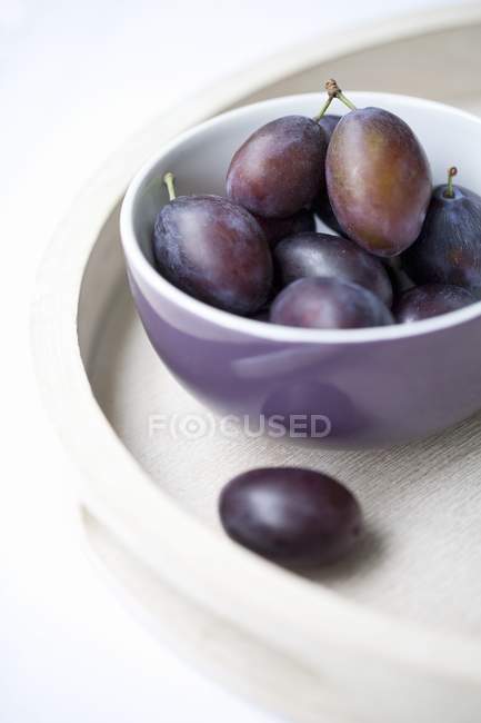Plums in Purple Bowl — Stock Photo