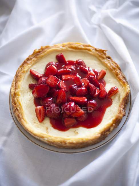 Strawberry cheesecake on tablecloth — Stock Photo