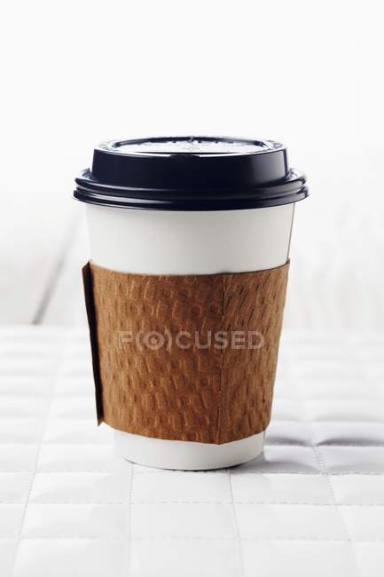 Vue rapprochée de tasse en papier pour boisson chaude sur surface blanche — Photo de stock
