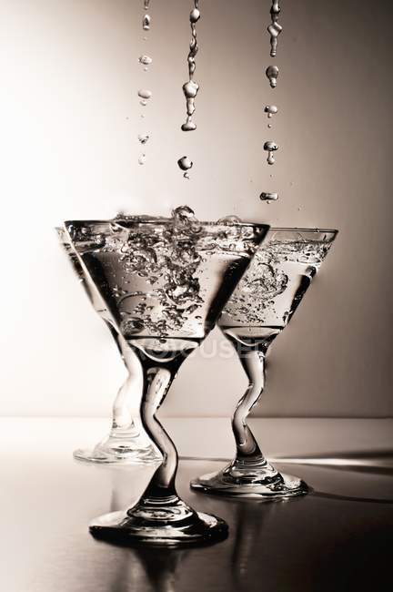 Martinis goteando y chapoteando en gafas - foto de stock