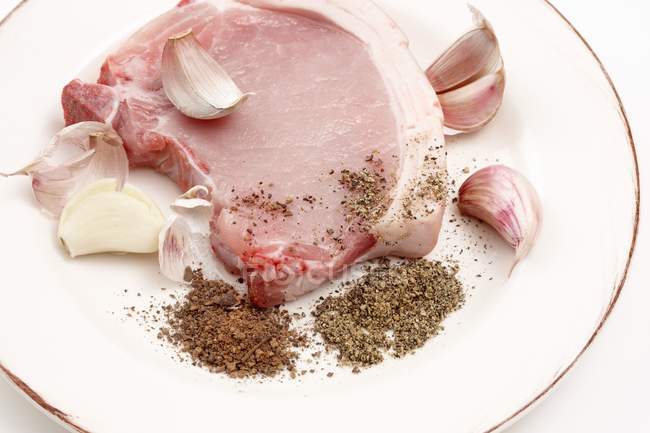 Costoletta di maiale cruda con aglio e spezie — Foto stock