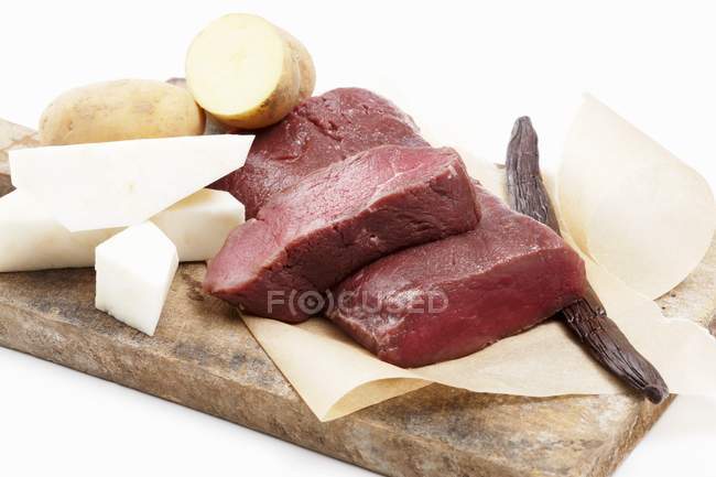Ingredientes para sela de veado com aipo-rábano e batatas sobre mesa de madeira — Fotografia de Stock