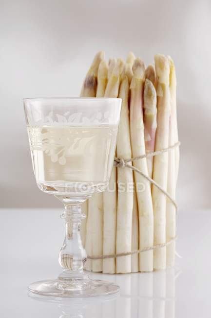 Bunch of asparagus and glass — Stock Photo