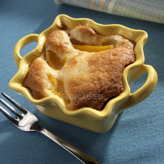 Closeup view of peach cobbler pie in yellow baking dish — Stock Photo