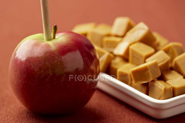 Primo piano vista di mela su bastone e caramelle caramello — Foto stock