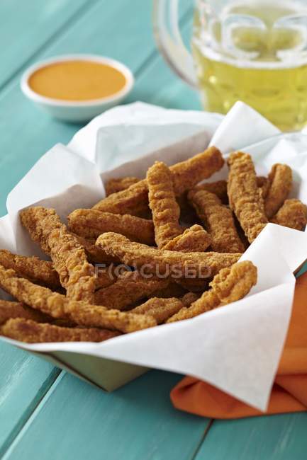Closeup view of chicken fries with beer and sauce — Stock Photo
