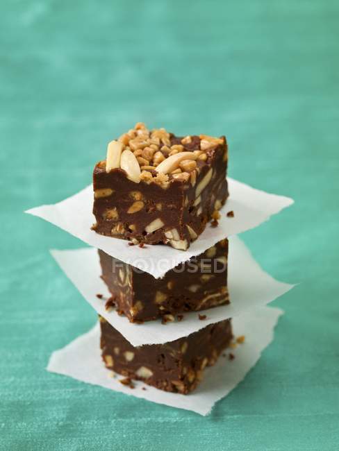 Vista de cerca de tres pedazos apilados de caramelo de chocolate Fudge - foto de stock