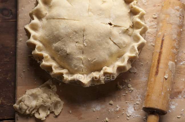 Nahaufnahme von oben von geformten rohen Kuchen und Nudelholz — Stockfoto